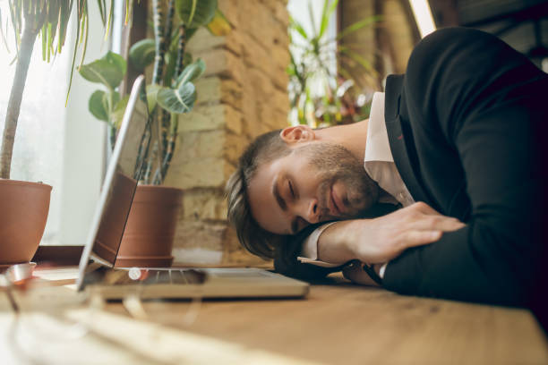 istock Young businessman in a black jacket napping in a cafe being tired after work 1281870071