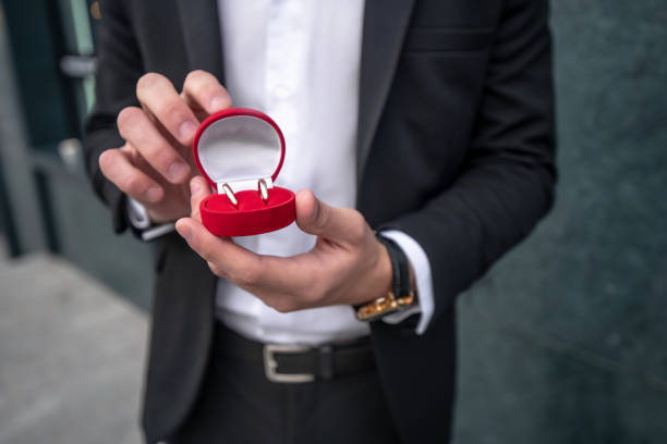 istock Close up of mans hands holding a box with engagement ring 1281870234