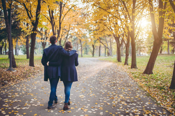 młoda para w parku - embracing heterosexual couple men women zdjęcia i obrazy z banku zdjęć