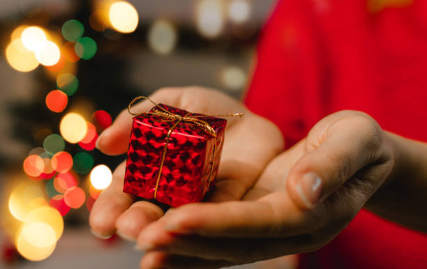 istock Woman's hands hold christmas or new year decorated gift box. Selective focus. 1281873662