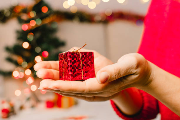 istock Woman's hands hold christmas or new year decorated gift box. Selective focus. 1281873668