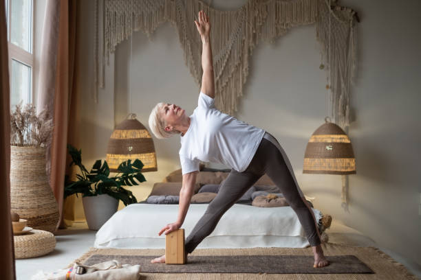 istock Senior woman practicing yoga, stretching in Utthita Trikonasana exercise, extended triangle pose 1281873732