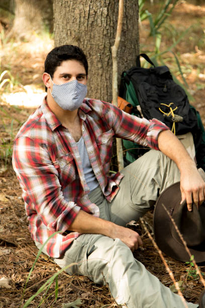 istock Hiker wearing protective face mask pauses next to a tree to rest. 1281873783