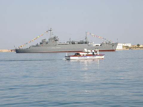 Military warship sailing in Neva River at St. Petersburg at sunset