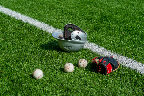 rękawica baseballowa, kask i piłka na trawie - baseballowa rękawiczka zdjęcia i obrazy z banku zdjęć