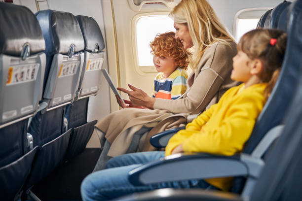 istock Woman inside a plane showing a tablet to a boy 1281875464