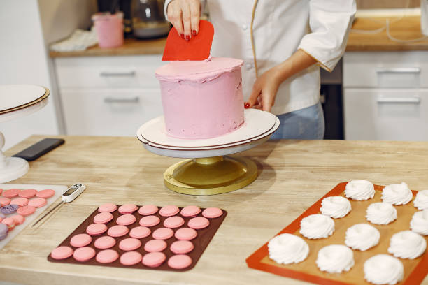 istock Confectioner in a uniform decorates the cake 1281877878
