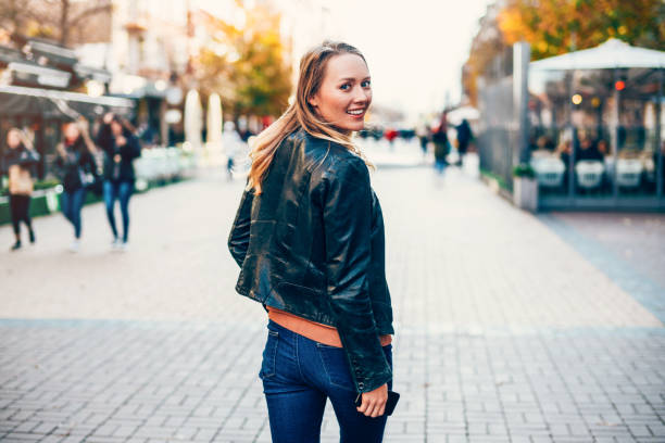 mujer alegre caminando por la ciudad. - women looking over shoulder people cute fotografías e imágenes de stock