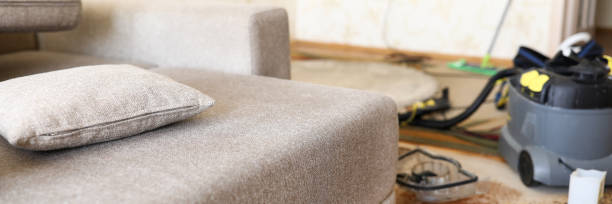 Sofa standing at domestic room with professional vacuum cleaner in background Sofa standing at domestic room with professional vacuum cleaner in background closeup couch arm rest stock pictures, royalty-free photos & images
