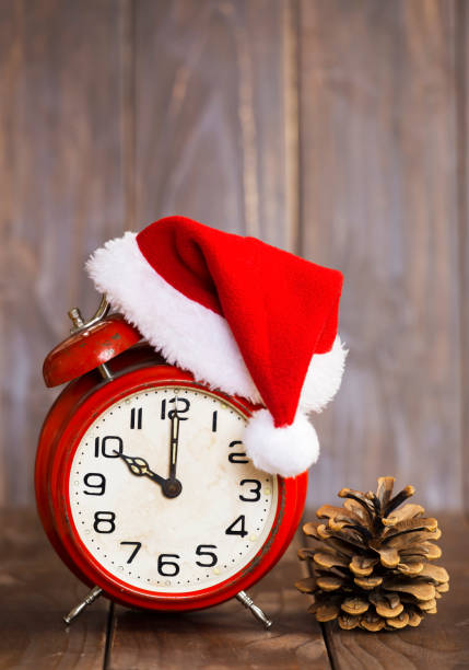 istock Alarm clock with red christmas santa hat and pine cone 1281882606