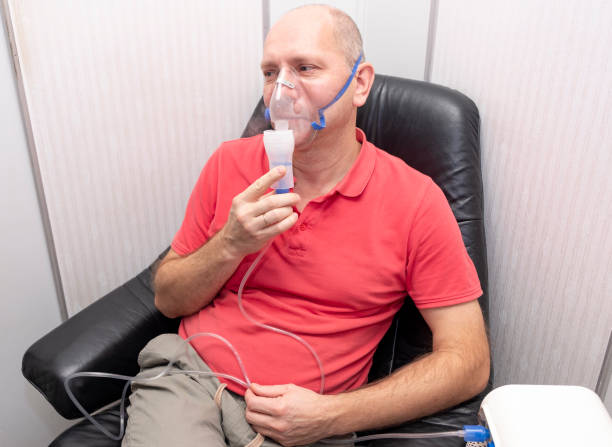 istock A Caucasian man, 40-50 years old, does inhalation with a nebulizer. 1281885682