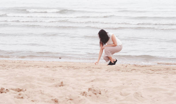 istock Asian woman walking alone on the beach. 1281890229