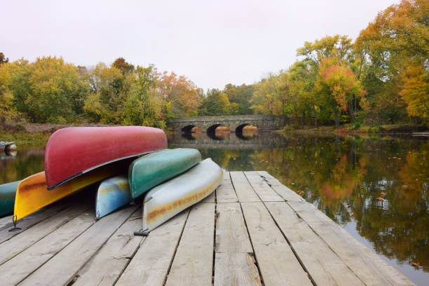 Canoes along Sudbury River in Concord, Massachusetts Canoes stacked up along the Sudbury River in historic Concord, Massachusetts. concord massachusetts stock pictures, royalty-free photos & images
