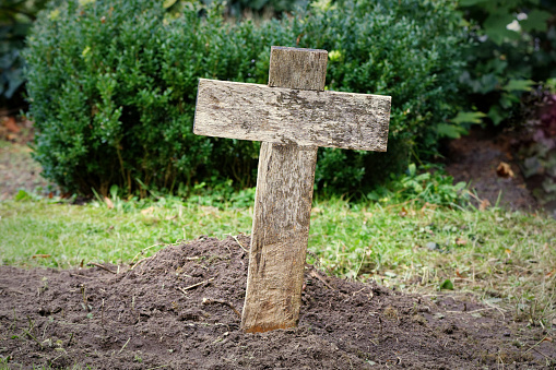 simple cheap wooden cross on a paupers grave