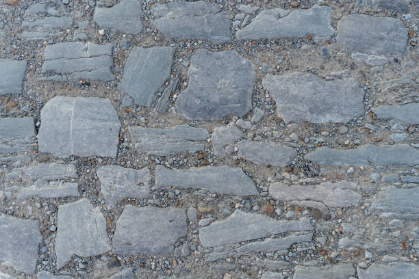 istock Closeup at stone path with stone of different size and grass between them, good for background, toned. 1281893505
