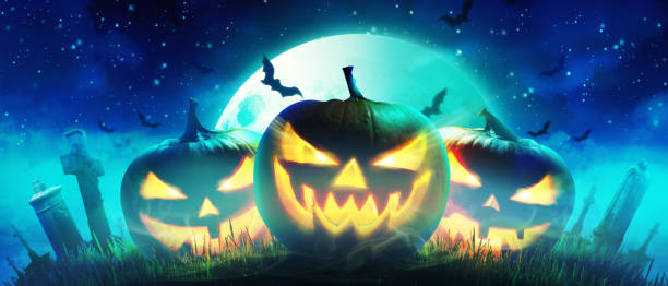 istock Halloween pumpkin face with burning fire inside in the graveyard. 1281894292