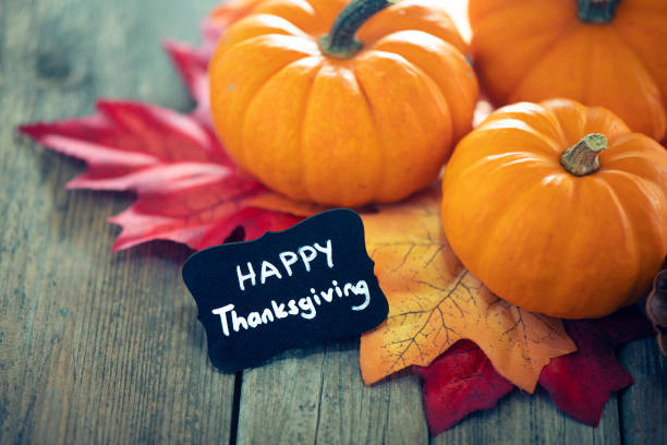 istock Thanksgiving decoration with pumpkins and greeting card on illuminated background and a rustic wooden table 1281896426