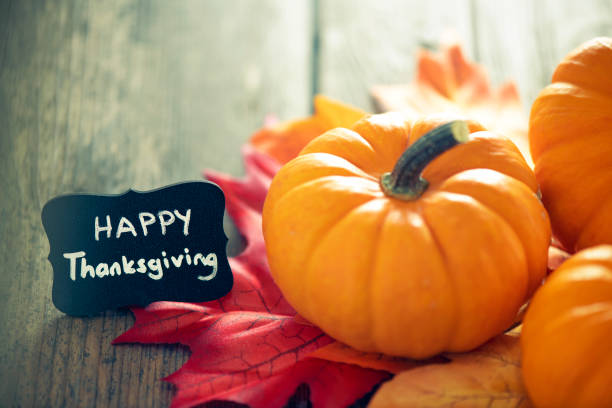 istock Thanksgiving decoration with pumpkins and greeting card on illuminated background and a rustic wooden table 1281898080