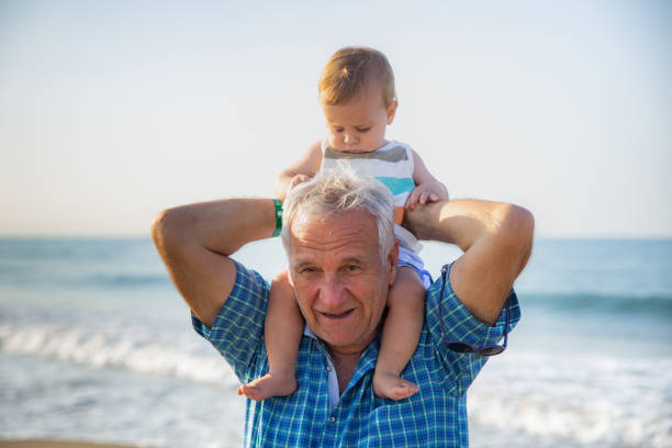 Grandfather taking his grandson at the beach