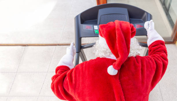 istock Santa Claus running on a treadmill in a gym 1281908361