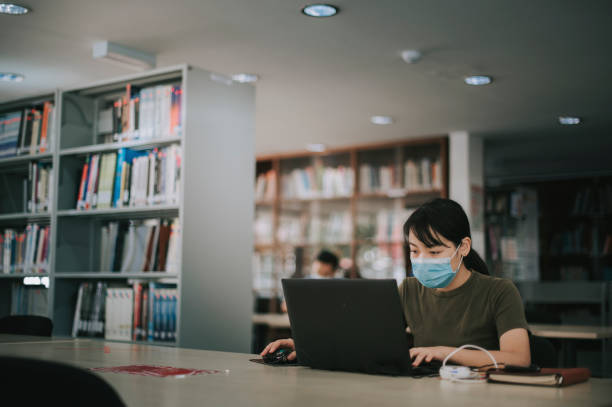 istock asian university student studying in library observing social distancing 1281913375