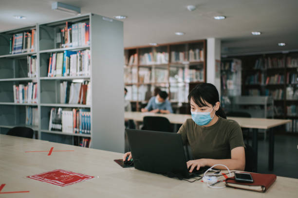 istock asian university student studying in library observing social distancing 1281913376