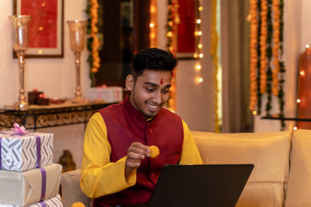 istock Young man in tradional wear at home using laptop 1281914972