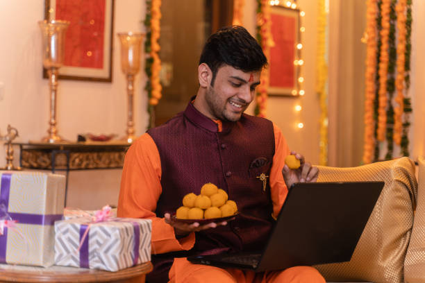 istock Young man ethnic wear using laptop on festival day 1281915069