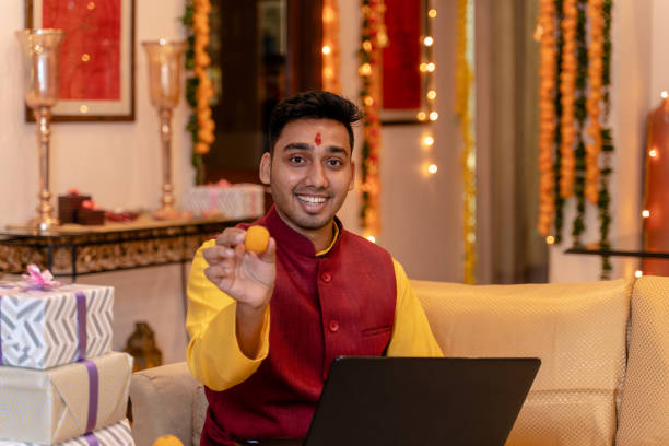 istock Young man in tradional wear at home using laptop 1281915214