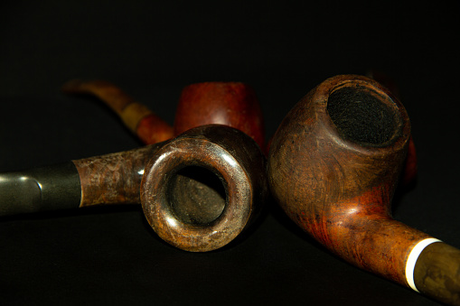 Tobacco smoking pipes made of heather wood on a dark background