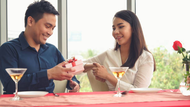 istock Romantic couple giving gift to lover at restaurant 1281919462