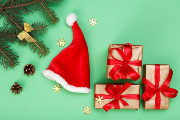 istock Santa's hat, gift boxes, fir tree branches with cones and snowflackes 1281920164