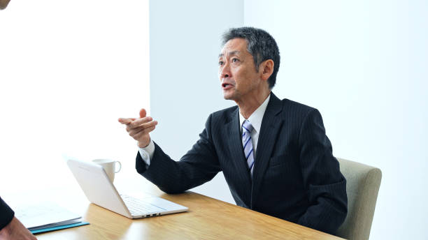 Scolding middle aged asian businessman in office. Scolding middle aged asian businessman in office. subordination stock pictures, royalty-free photos & images