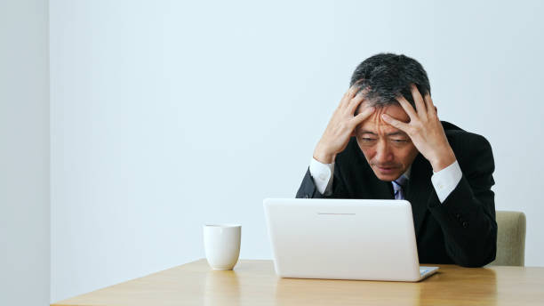 istock Depressed middle aged businessman with a laptop computer. 1281924051