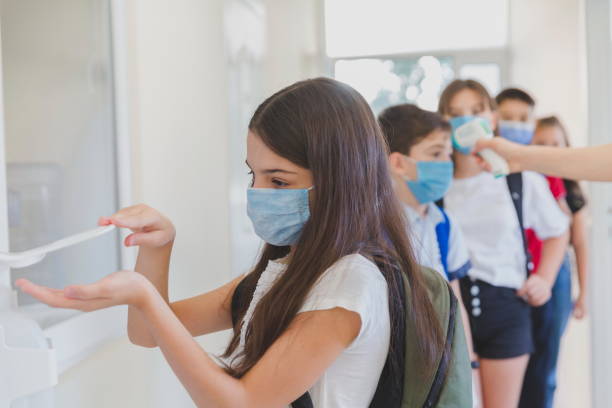 istock Little girl disinfecting hands while entering school. 1281926692