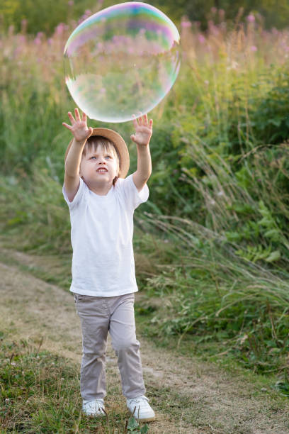 istock Happy boy catching soap bubbles in nature in summer 1281928349