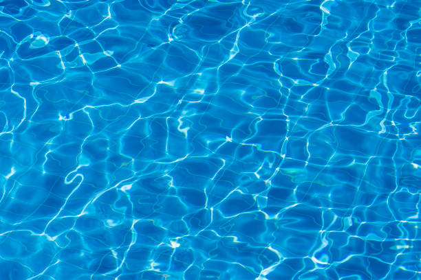 istock Water ripples on blue tiled swimming pool background. Top view 1281935624