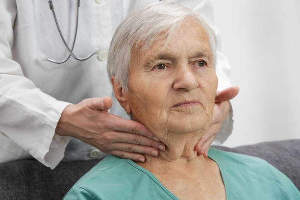 istock Doctor examining senior woman's thyroid glands or tonsils 1281936519