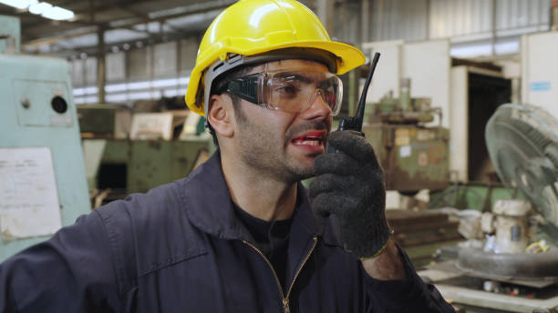 istock Factory worker talking on portable radio while inspecting machinery parts 1281943037