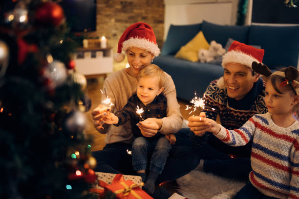 istock Happy parents and their small kids using sparklers while celebrating on Christmas eve. 1281945389