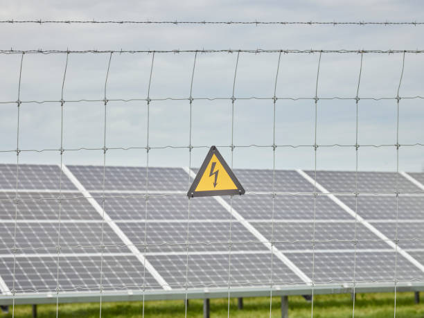 Electric fence in front of Solar Panels stock photo