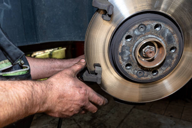 istock A car mechanic pulls a brake caliper in a car standing on a car jack in the workshop. 1281949835
