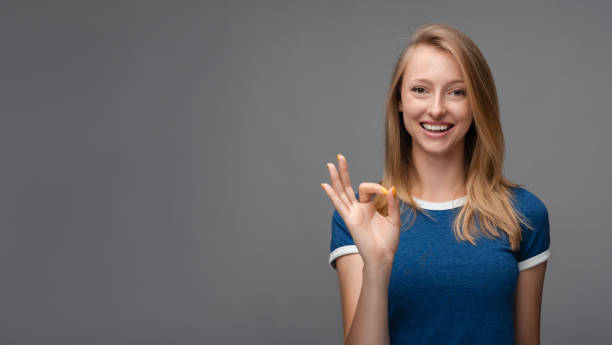 istock Cheerful girl is looking at the camera with happy expression, showing OK gesture 1281952844