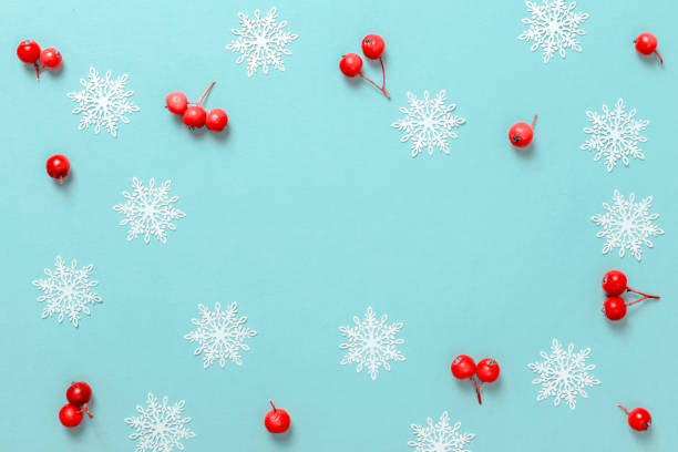 istock Christmas pattern. White snowflakes, red berry in Christmas composition on pastel blue background for greeting card. Winter festive composition with copy space. 1281954574