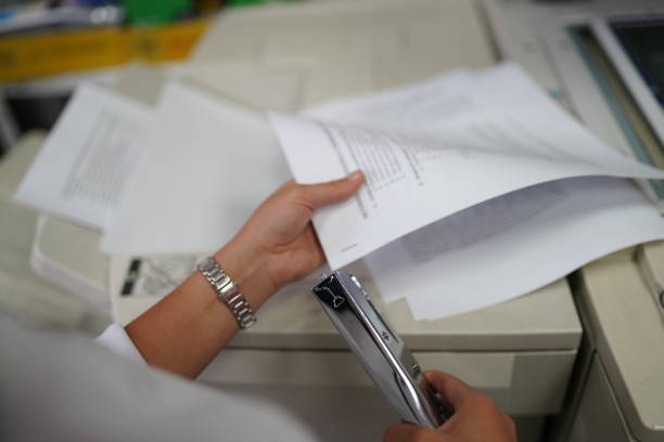 istock Woman hands holding papers and stapling documents in office 1281955538
