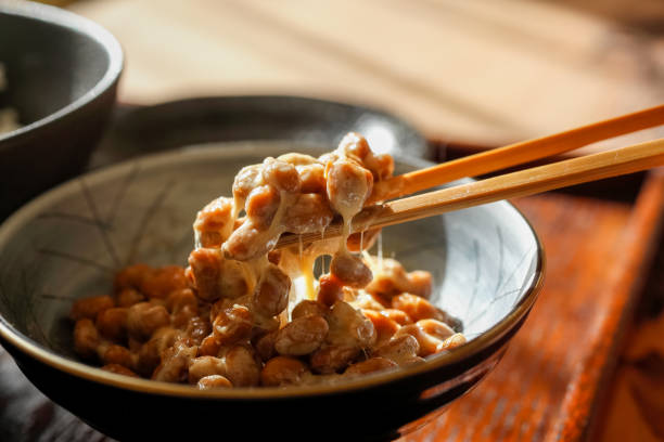 Natto A scene on the verge of stirring Fermented soybeans
 in a small bowl and putting it on rice with chopsticks. natto stock pictures, royalty-free photos & images