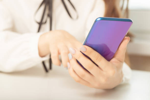 istock female hands uses the phone at the table, prints SMS, social media, mobile apps 1281958351