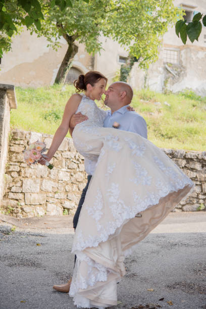 istock Bridegroom Carrying Bride Outdoors 1281960428