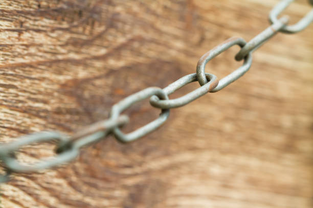 Old rusty metal chain on a wooden background. Selective focus