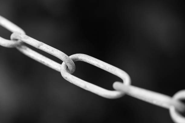 istock Metal chain on a dark background. Black and white photo. Selective focus 1281961478